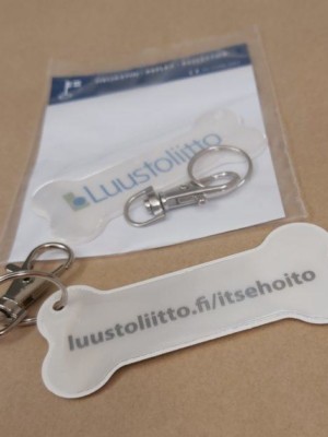 Kuva kahdesta heijastimesta, toisessa näkyy Luustoliiton logo, toisessa taustapuolen teksti..